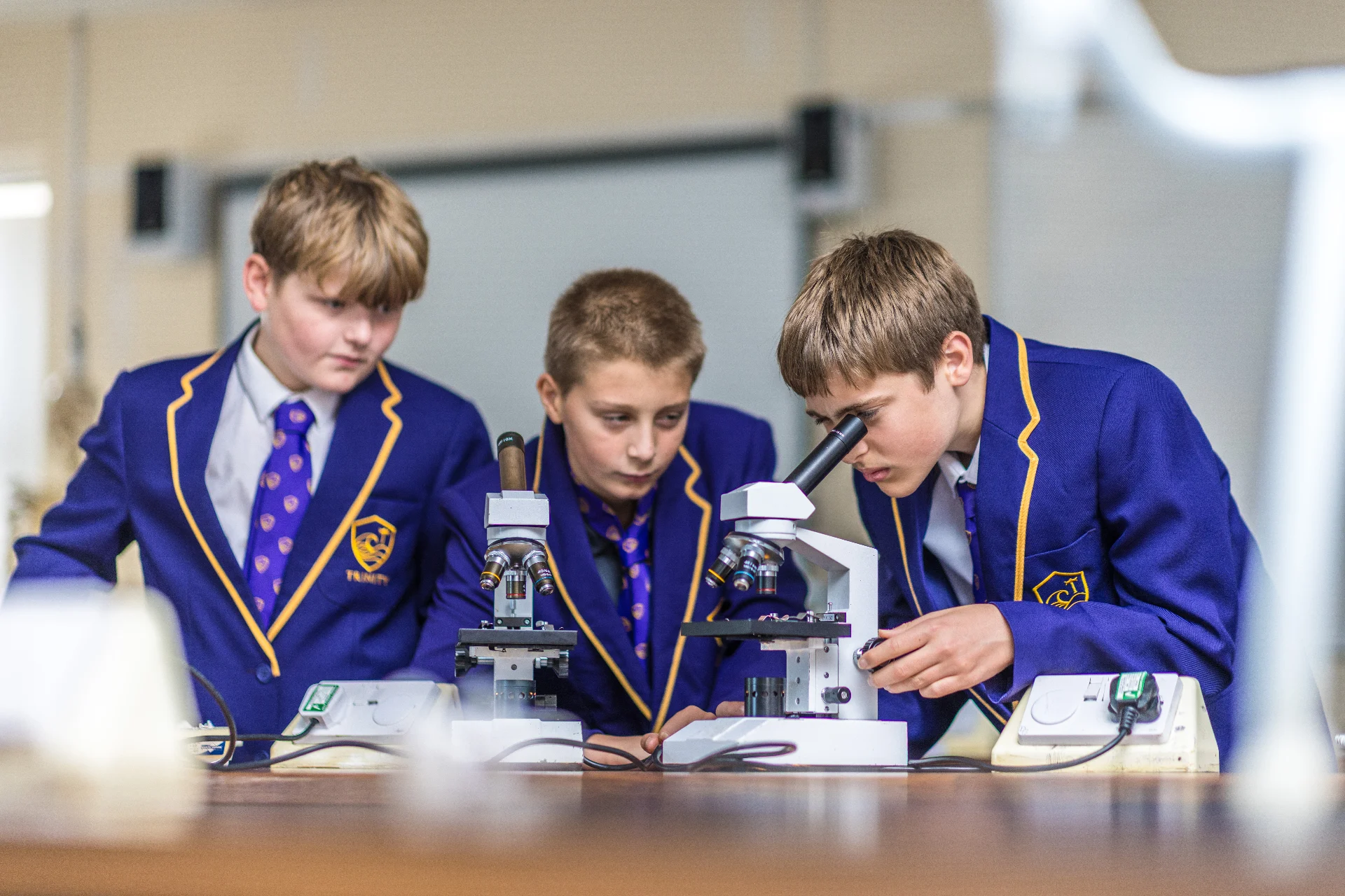 Trinity Senior School pupils in blazers using microscopes in a science lesson